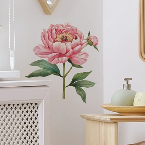 Detail of vintage pink peony floral wall sticker with green leaves on a beige wall