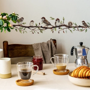 Detail of bird wall decals on a cozy kitchen wall showing matte texture and leaf accents