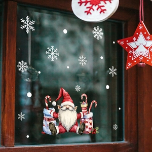 Detail of Santa gift bags and snowflake stickers on a wooden frame window display