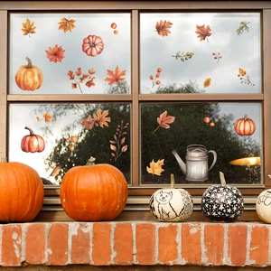 Detail view of fall window stickers featuring maple leaves pumpkins and a vintage water pot