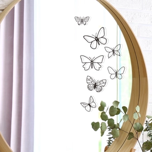 Detail of minimalist black butterfly wall decals on a mirror in a modern home setting