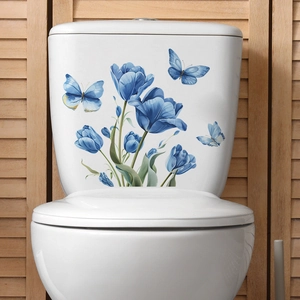 Adesivi murali con tulipani blu e farfalle applicati su un serbatoio del WC bianco