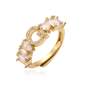 Dettaglio dell'anello dorato regolabile con lettera G e zirconi a taglio misto