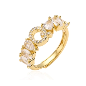 Dettaglio di un anello dorato regolabile con zirconi a forma di cuore e a goccia