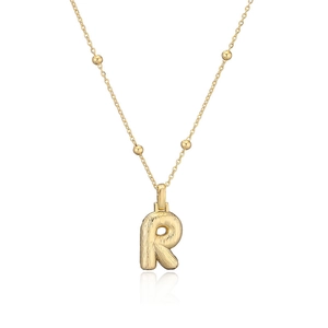 Détail du pendentif lettre R doré avec une surface métallique texturée et brillante