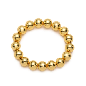 Detalle de una pulsera elástica con cuentas doradas pulidas en un set de 7 joyas de lujo
