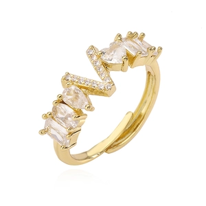 Dettaglio macro di un anello placcato oro con zirconi a cuore e a goccia brillanti