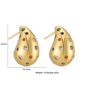 Boucles d'oreilles gouttes dorées avec cristaux colorés et perles sur fond blanc
