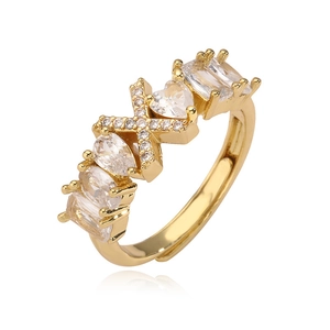 Dettaglio dell'anello dorato aperto con zirconi a cuore, goccia e la lettera X di cristallo