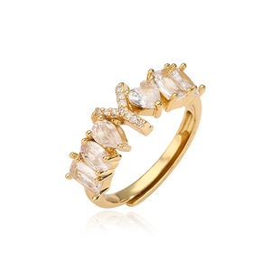 Dettaglio di un anello regolabile dorato con zirconi a forma di goccia e cuore scintillante