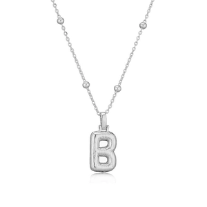 Vue détaillée du collier argenté avec pendentif lettre B et texture martelée polie