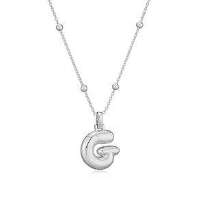Détail macro du collier pendentif lettre G ballon bouffi avec plis métalliques en argent