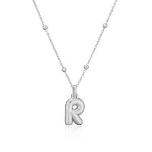 Vue détaillée du pendentif lettre R argenté avec finition en métal brossé et texture fine