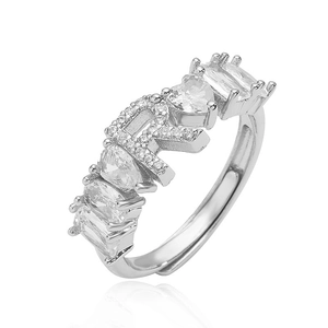 Dettaglio dell'anello d'argento con lettera R e pietre di zircone a cuore e a goccia
