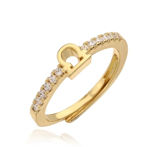 Macro detail of gold Libra zodiac ring featuring sparkling cubic zirconia stones