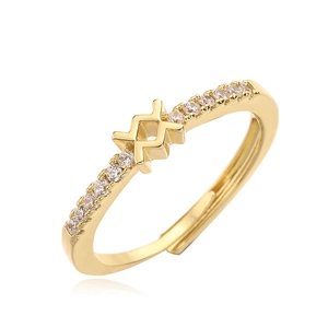 Detailed view of golden open ring with criss-cross X design and zircon stone inlay