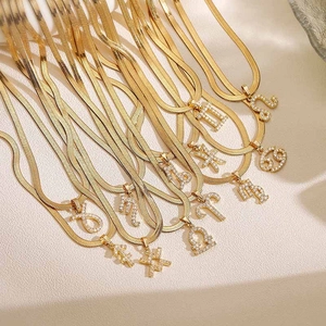 Detailweergave van gouden slangenkettingen met sterrenbeeldhangers en kristallen