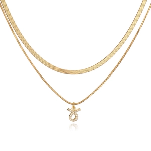 Detailed view of layered gold snake chain necklace with a crystal Taurus zodiac pendant