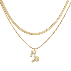 Detail of gold double-layered snake chain necklace with Capricorn zodiac pendant