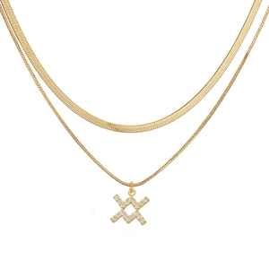 Close-up of double-layered gold snake chain necklace with a sparkling pavé X pendant