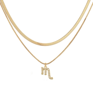 Detail of gold double-layered necklace with snake chain and crystal Scorpio pendant