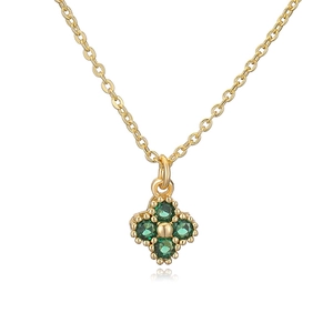 Close-up of gold clover necklace pendant with four emerald green faceted gemstones