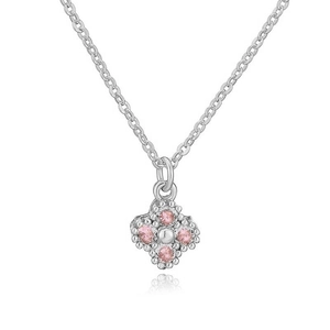 Macro shot of a clover pendant necklace with pink zircon stones and silver metallic texture