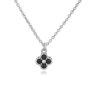 Detailed macro of silver four-leaf clover necklace with black stones and beaded edge
