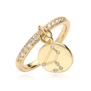 Macro view of adjustable gold ring featuring a sparkling zodiac constellation pendant