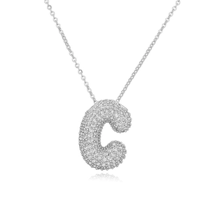 Dettaglio macro del ciondolo a lettera C in argento con pavé di micro zirconi cubici