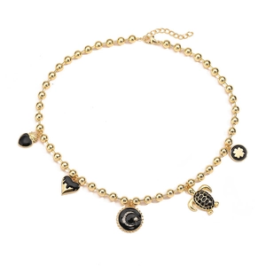 Detail of gold beaded necklace with black enamel heart, turtle and clover pendants