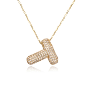 Dettaglio macro del ciondolo a lettera T dorato con pavé di zirconi e catena a maglie