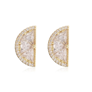 Macro shot of D-shaped gold stud earrings featuring clear triangular zircon and pavé crystals