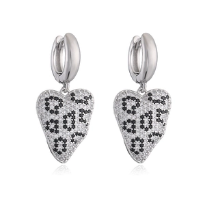 Dettaglio di orecchini a cuore in argento con cristalli pavé con motivo leopardato