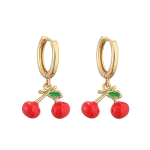 Detail of gold hoop earrings featuring red enamel cherry charms and green leaves