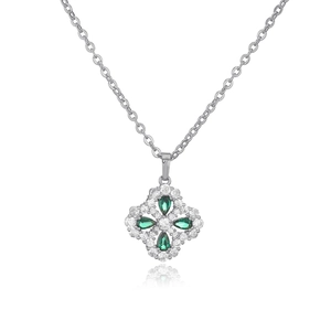 Macro detail of silver four-leaf clover pendant with green crystals and pave halo