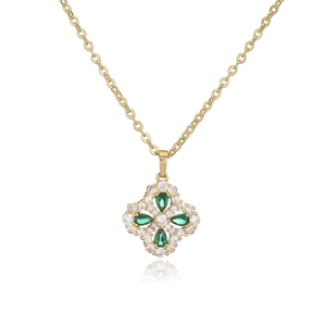 Macro shot of a clover pendant necklace featuring green gemstones and white crystals