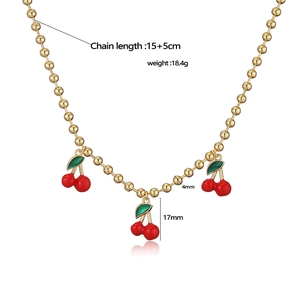 Collana a sfere dorate con ciondoli a ciliegia in smalto rosso dallo stile naturale