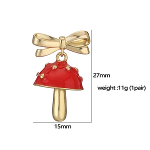 Dettaglio degli orecchini a fungo rosso con fiocco dorato e dimensioni di 27mm per 15mm