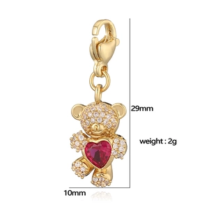 Detailed view of gold teddy bear pendant with red heart gemstone and white zircons