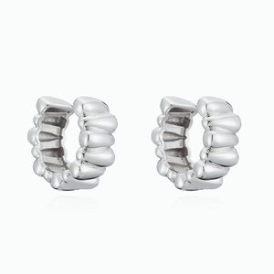 Macro detail of silver C-shaped textured ear cuffs with unique ribbed metal design