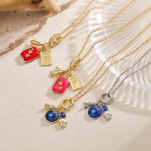 Detailed macro view of enamel traveler and astronaut pendants on gold and silver chains
