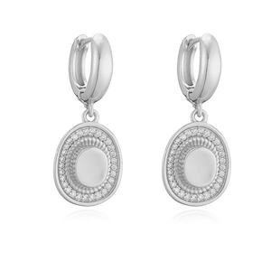 Close-up of silver oval hoop earrings with sparkling zircon pave edges on white background