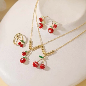 Detailed set of cherry jewelry with red enamel necklaces, earrings and open ring on a stand