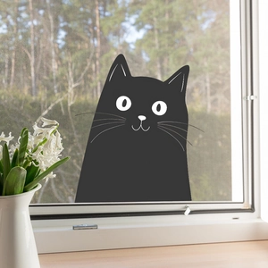 Detailed view of a cute black cat wall sticker applied on a white window frame
