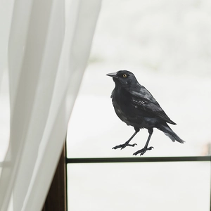 Realistic black bird window sticker for home decor on a glass window with soft curtains