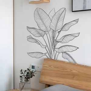 Détail des stickers muraux feuilles tropicales noires dessinés à la main dans une chambre