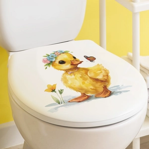 Detailansicht von gelbem Enten- und Schmetterlingsaufkleber auf weißem WC-Deckel