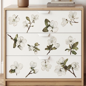 Detail of white pear flower wall stickers on a light wood drawer in a Nordic style room