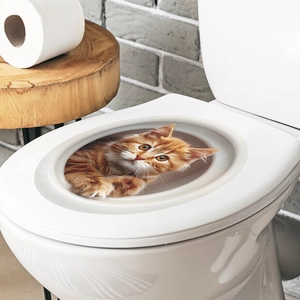 Realistic 3D orange cat toilet sticker on a white lid creating a cute visual depth